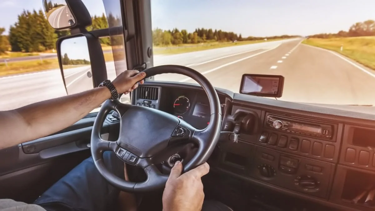 Boost Driver Safety with Elite EXTRA Fleet Telematics - header image with person driving a semi truck down the road